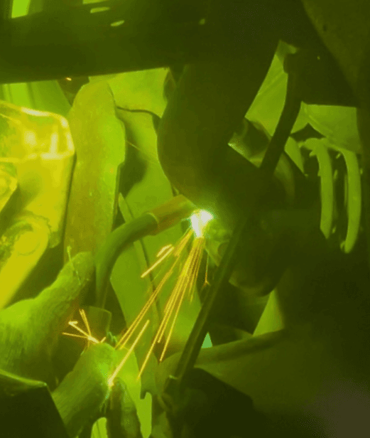 MIG welding — sparks flying, viewed through a welding helmet